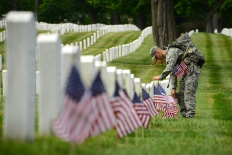Army Sgt. Titus Fields of the 3rd U.S. Infantry Regiment -- The Old Guard -- places an American flag in front of a gravestone in Arlington National Cemetery, Arlington, Va., May 23, 2013. (U.S. Army photo by Sgt. Jose A. Torres Jr.) 